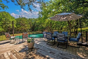 A wooden deck with outdoor furniture, a table, and chairs, overlooking a swimming pool. - Texoma/Tanglewood Highport Marina - Adorable Cottage!
(Pottsboro)