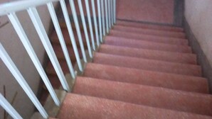 A staircase with a white handrail and red steps. - Bahamas Resort (Thika)