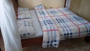 A single bed with a canopy, a checkered bedspread, and pillows. - Bahamas Resort (Thika)