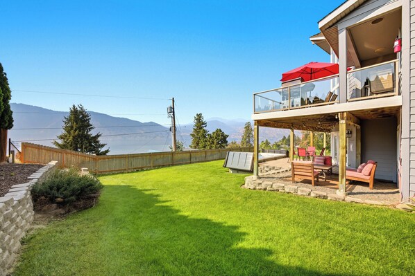 Une maison à deux étages dotée d’un balcon, d’une terrasse avec mobilier d’extérieur et offrant une vue sur les montagnes.