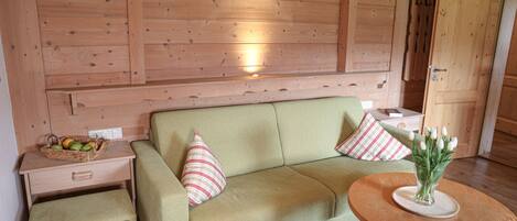 A wooden interior with a sofa, a small table, and a bench.