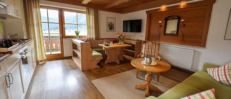 Un intérieur en bois comprenant une cuisine, un coin repas et un salon.