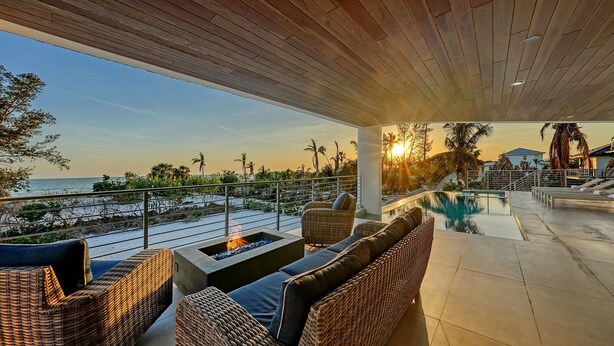 A covered outdoor area with wicker furniture, a fire pit, and a pool. - Steps to Beach-Full gulf views infinity pool-EXQUISITE! Ask @ seasonal specials! (Longboat Key)