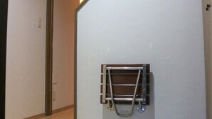 A staircase with a metal handrail, a wooden floor, and a tiled wall. - Sadie's Home (Kawasaki)