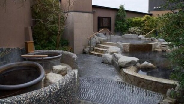 A traditional Japanese onsen with stone baths and a stone pathway. - Sadie's Home (Kawasaki)