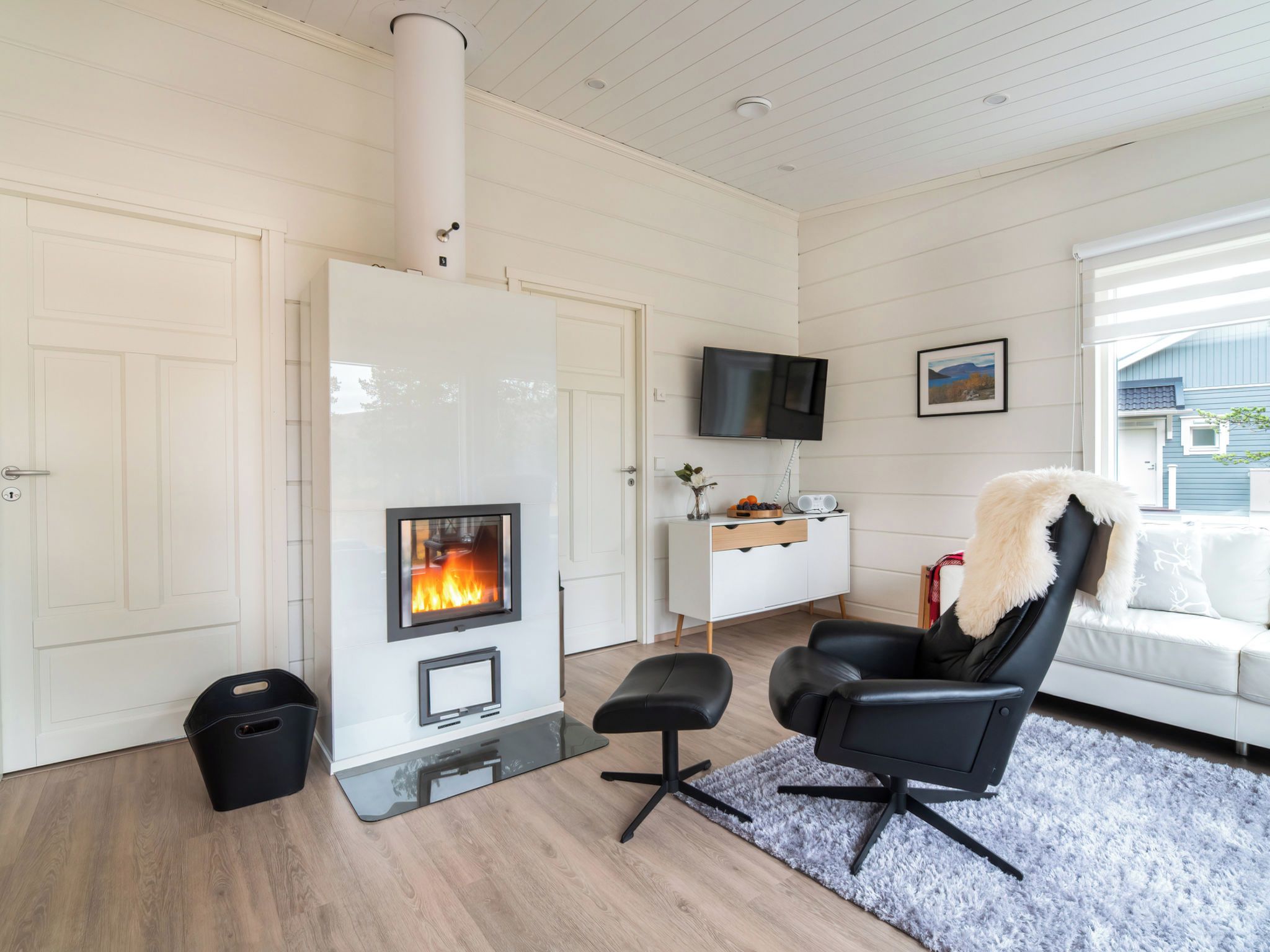 Un salon moderne doté d’une cheminée, d’un téléviseur à écran plat et d’un coin salon confortable.