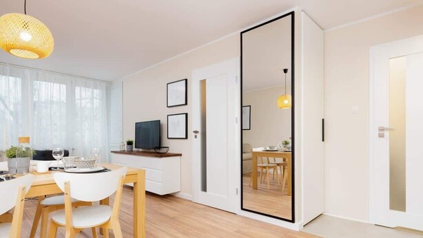 Una cocina moderna con armarios de madera, una mesa de comedor con sillas y un espejo grande en la pared.