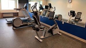 A gym with cardio machines, a bench, and a large mirror. - Microtel Inn & Suites by Wyndham Fountain/Fort Carson (Fountain)