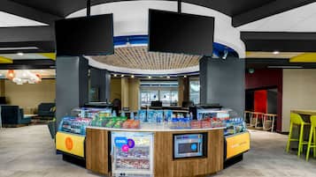 Een toonbank met een drankdispenser, een koelvitrine en een digitaal scherm.