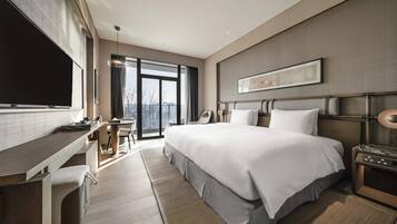 Een moderne hotelkamer met een groot bed, een bureau en een televisie.