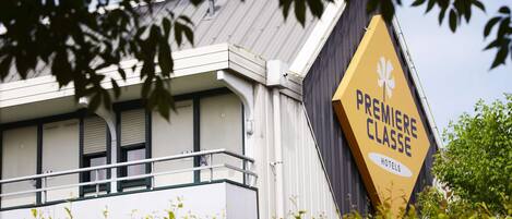 Un edificio con un letrero amarillo llamativo que dice "PREMIERE CLASSE HOTELS".