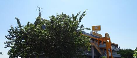 Un hotel con un letrero amarillo llamativo, una antena parabólica y una escalera que lleva a la entrada.