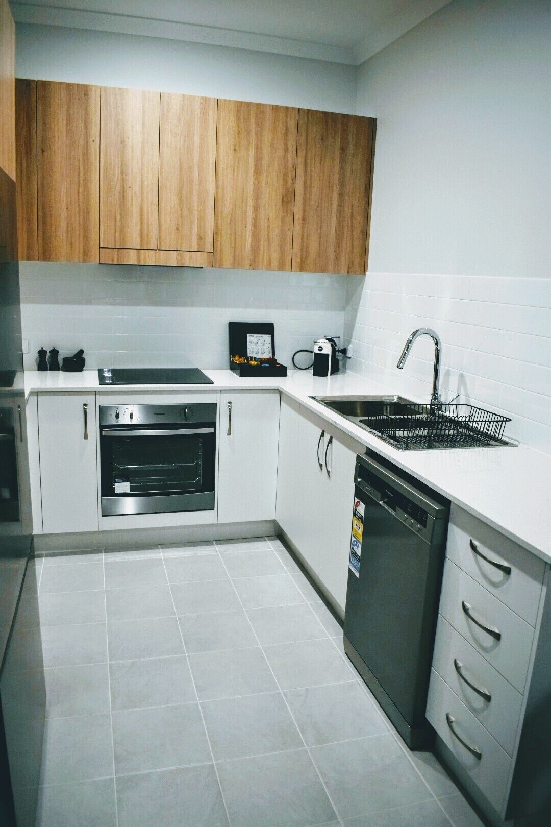A modern kitchen with white cabinets, stainless steel appliances, and a tiled backsplash.