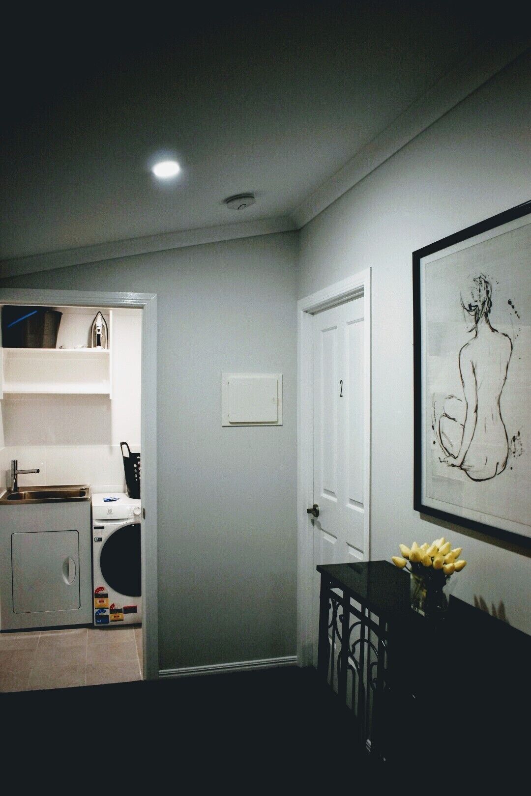 A compact kitchen with a washing machine, a sink, and a dining area with a table and chairs.
