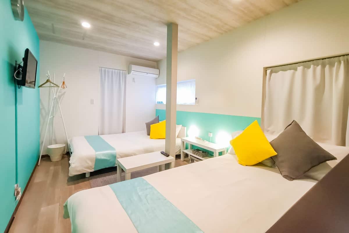 A hotel room with two beds, a desk, and a chair.