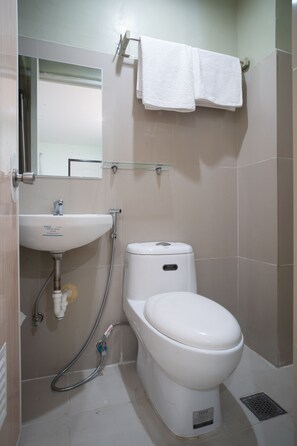 A bathroom with a white sink, toilet, and a glass shower enclosure. - Super OYO 604 Chateau Cinco Dormitel - Hostel (Davao)