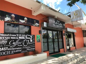 A coffee shop with a sign for 'Blend FaB Caffè' offering coffee, frappe, and milk tea. - Guest Hotel (Pili)