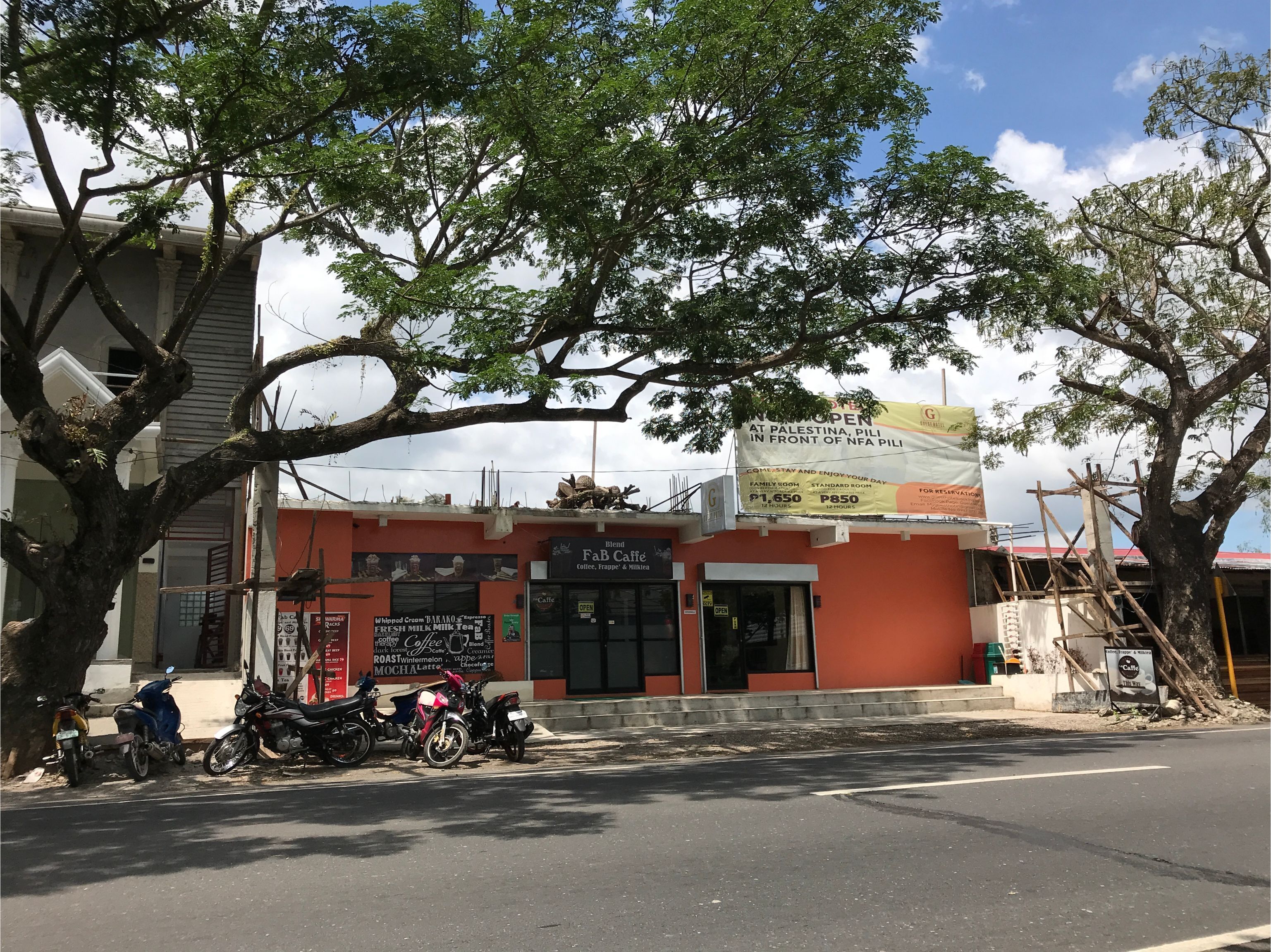 A café with a signboard advertising a family room and standard room rates.