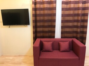 Familien-Suite | Wohnbereich | 32-Zoll-Flachbildfernseher mit Kabelempfang, Fernseher