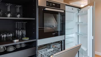 Una cocina moderna con horno empotrado, lavavajillas y espacio para vinos.