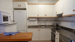 A kitchen with white cabinets, a microwave, a toaster, and a dishwasher.