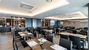 A modern restaurant with multiple dining tables, black chairs, and a bar area. - Ramada Hotels & Suites Seoul Namdaemun (Seoul)