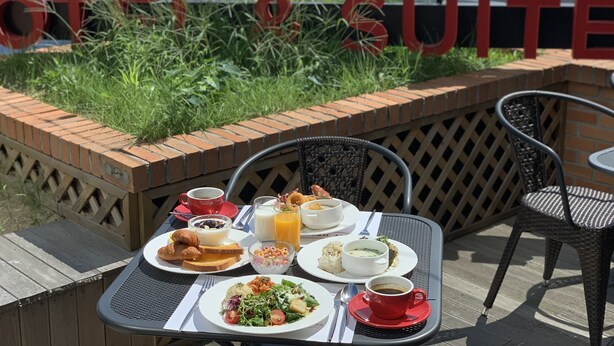 A breakfast table with various dishes, a red cup, and a sign reading "RAMADA CITY & SQUITE". - Ramada Hotels & Suites Seoul Namdaemun (Seoul)