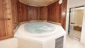 A hot tub with wooden walls and a tiled floor.