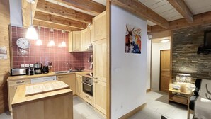 A modern kitchen with wooden cabinets, a built-in oven, and a red-tiled backsplash.