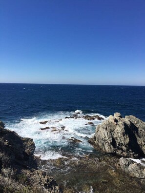 Paisagem costeira com afloramentos rochosos e o oceano.