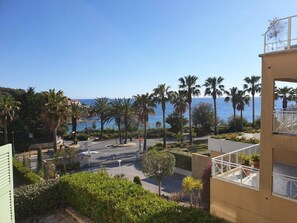 Une vue sur la côte, avec des palmiers et un ciel dégagé.