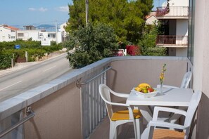 Enjoy a peaceful moment on this balcony with a table, chairs, and beautiful views of the surrounding area.