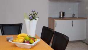 Ein Esstisch mit Obstschale und Blumenvase.