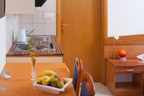 Enjoy a meal in the room's dining area, which features a table set for a meal and a vase with flowers.