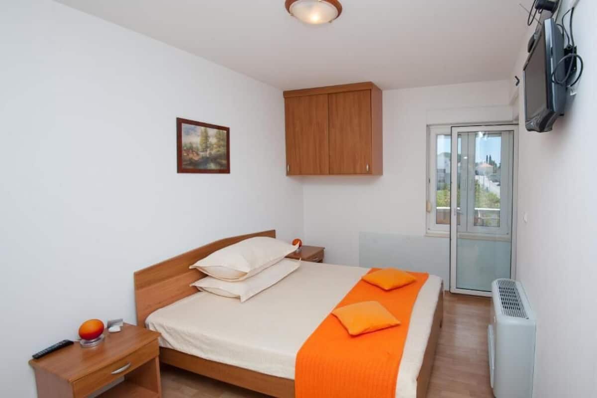 Relax in a cozy bedroom with a comfortable bed, wooden wardrobe, and a TV for entertainment.