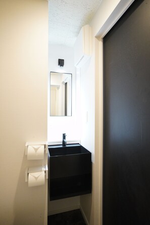 Standaard driepersoonskamer | Badkamer | Een haardroger, badjassen, pantoffels, een bidet