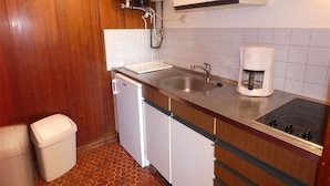 Uma cozinha compacta com pia, cafeteira e lava-louças.