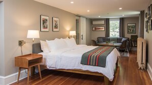 A bedroom with a wooden bed, bedside tables, a desk, and a chair. - Granville House (Housatonic)