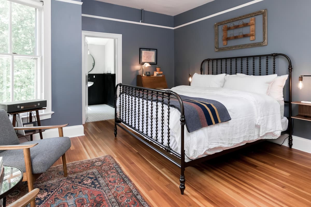 A bedroom with a bed, a desk, and a chair.