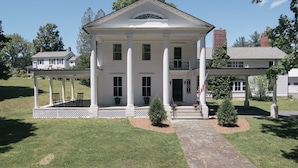 A large, two-story white building with a symmetrical facade, columns, and a central entrance. - Granville House (Housatonic)