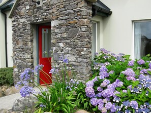 A stone building with a red door and number 15. - Waterville Holiday Homes (Waterville)