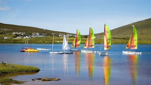 A calm lake with sailboats and a few houses in the background. - Achill Sound Holiday Village (Achill Island)