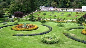 A meticulously landscaped garden with geometric flower beds and a variety of shrubs. - Galway Bay Lodge (Oranmore)