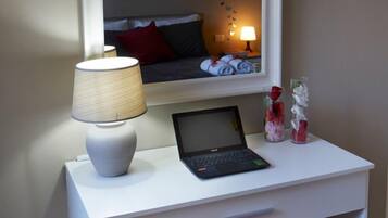 A white desk with a laptop, a lamp, and decorative items.