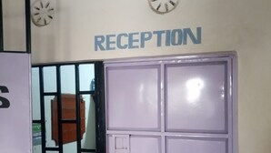 A reception area with a sign above a set of lockers. - Dakaka Lodge (Nakuru)
