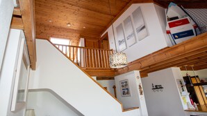 Ein Holzinnenraum mit Treppe, Essbereich und Küche.