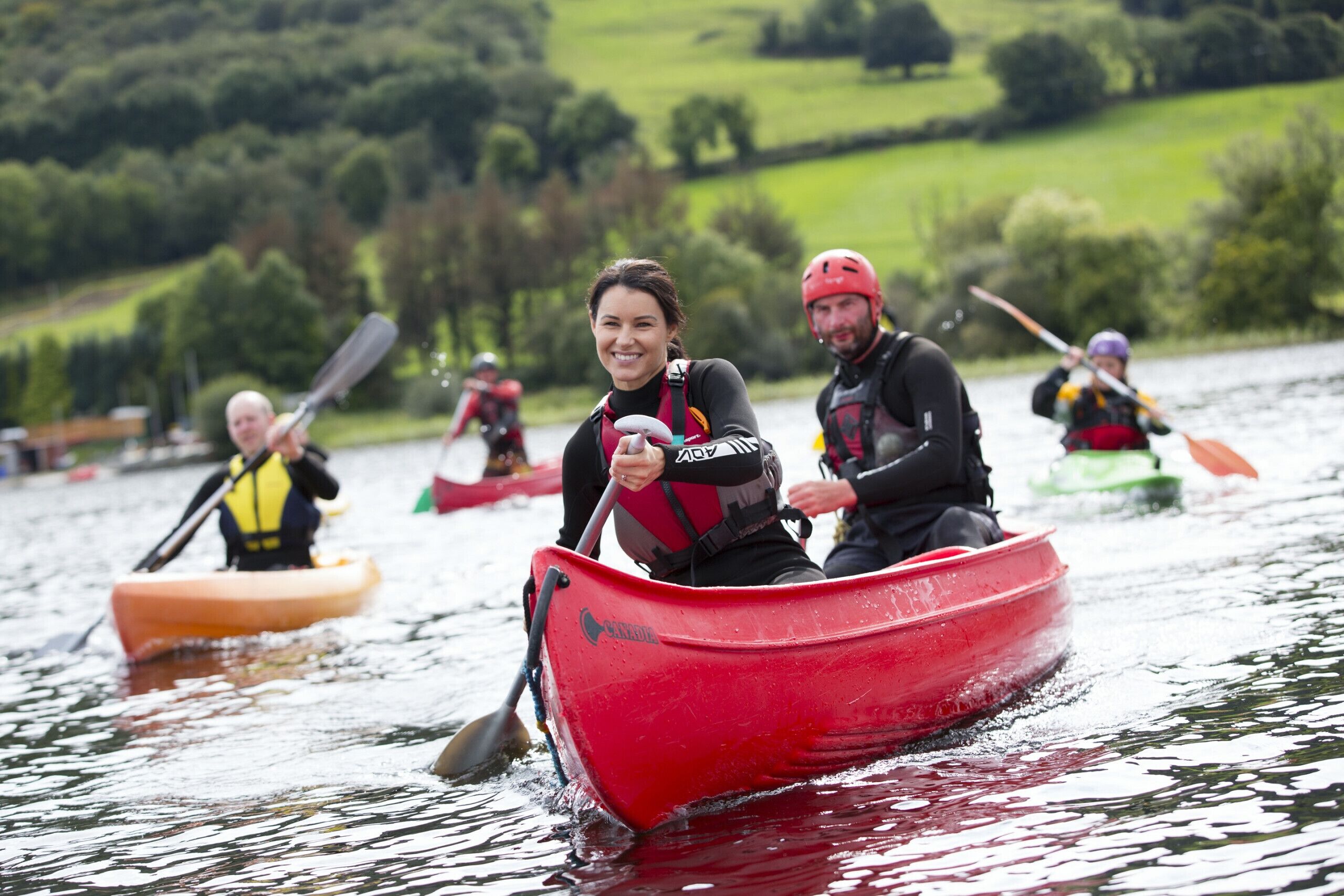 Un grupo de personas en un canoa roja en un lago.