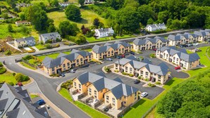 A residential area with multiple two-story houses, a central road, and a railway track. - Lakeside Holiday Homes (Killaloe)