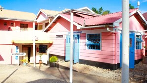 A pink building with a reception area and a restaurant sign. - Diamond Rock Resort & Guest House (Kakamega)