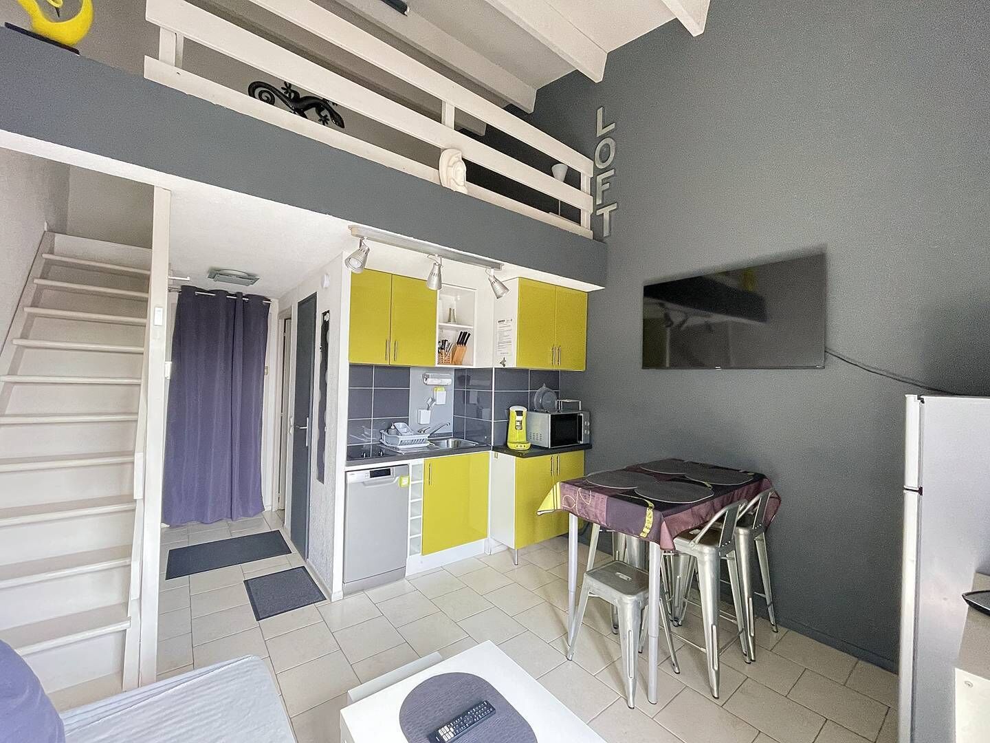 A compact kitchen with a dining area, a built-in microwave, and a refrigerator.